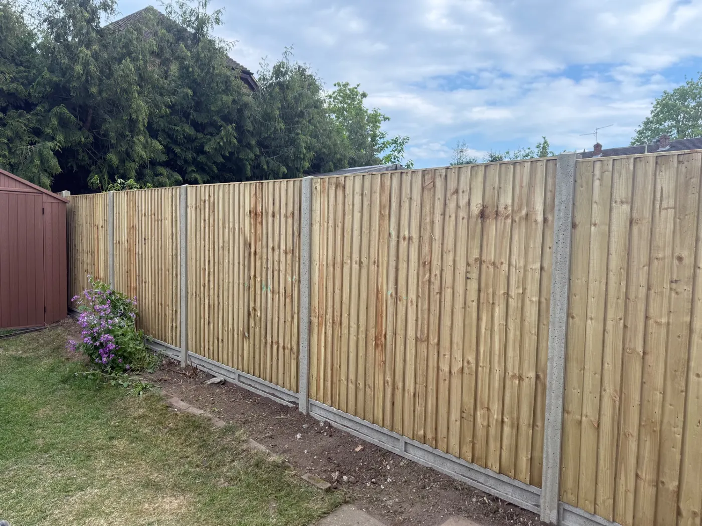 Long run of closeboard fence panels and gravel boards in a Haslemere garden