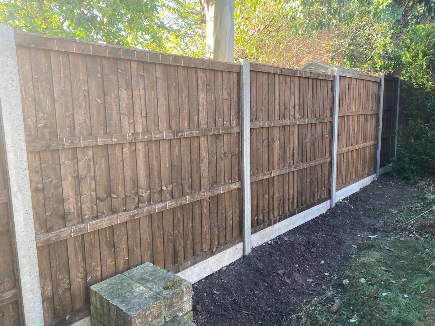 Brown closeboard fence panels fitted with concrete posts and gravel boards in a Haslemere garden