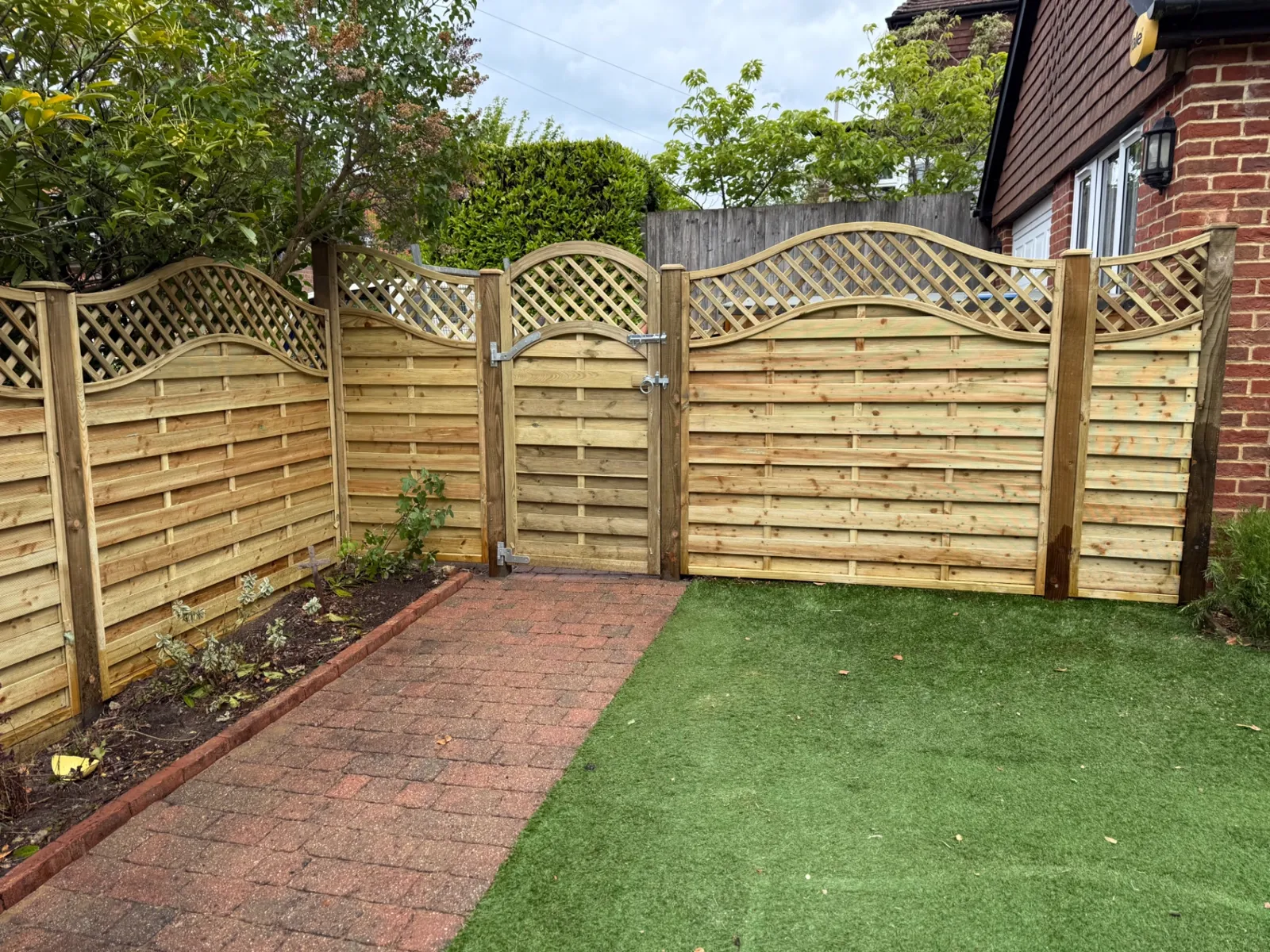 Wave trellis top garden gate matching new fence panels in Haslemere